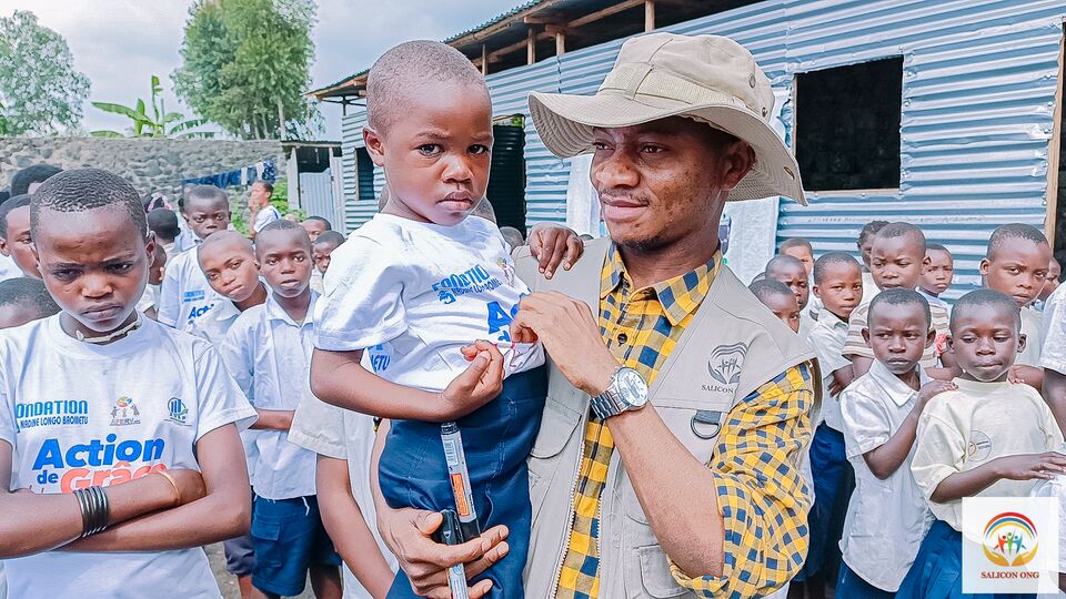Un enfant accompagné par un membre de l’équipe, SALICON RDC.
